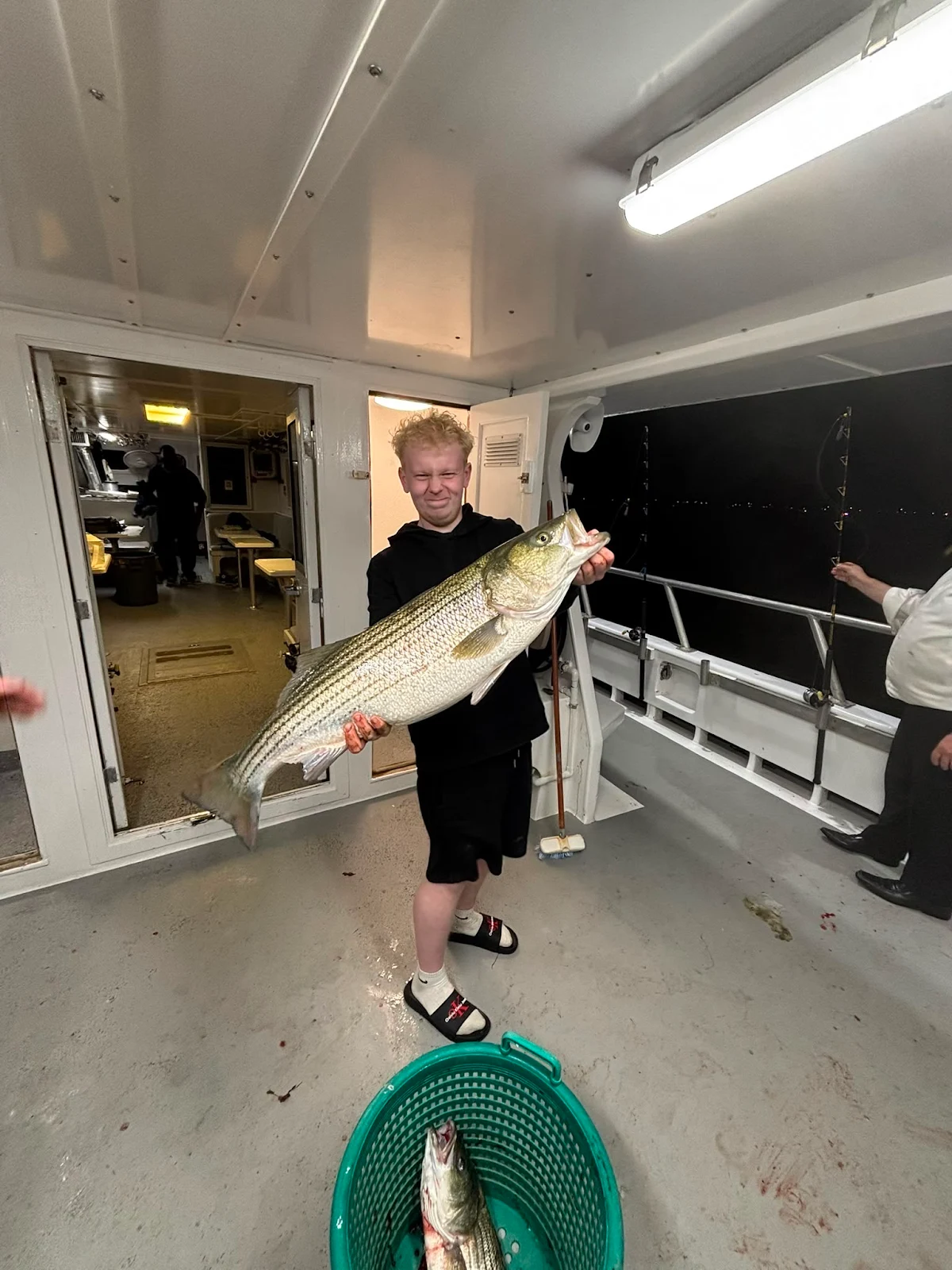 Lucas Chalmers with a Striped Bass caught on a charter in Boston