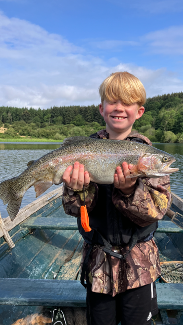 Finn Scobie with a Rainbow Trout caught fly fishing at Lochmill with his dad